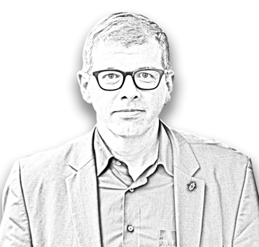 Matthias Zehnder, Foto als Bleistiftzeichnung. Kurze Haare, dick umrandete Brille, leichtes Lächeln, Hemd und Jacket mit kleinem Pin im Knopfloch