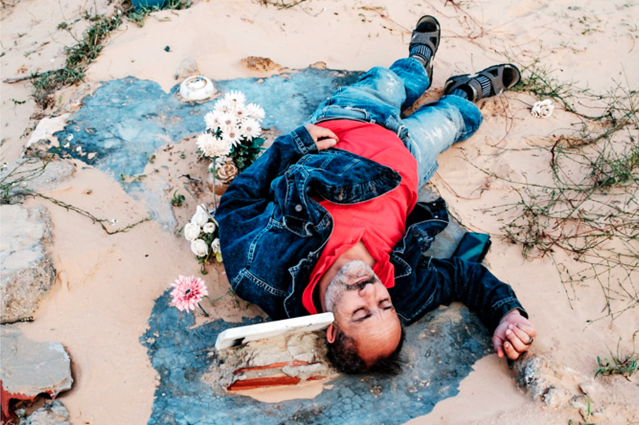 Chamseddine Marzoug liegt auf dem Grab von Rosemarie aus Nigeria – dem einzigen Grab, das eine Inschrift trägt. | Foto: Klaus Petrus