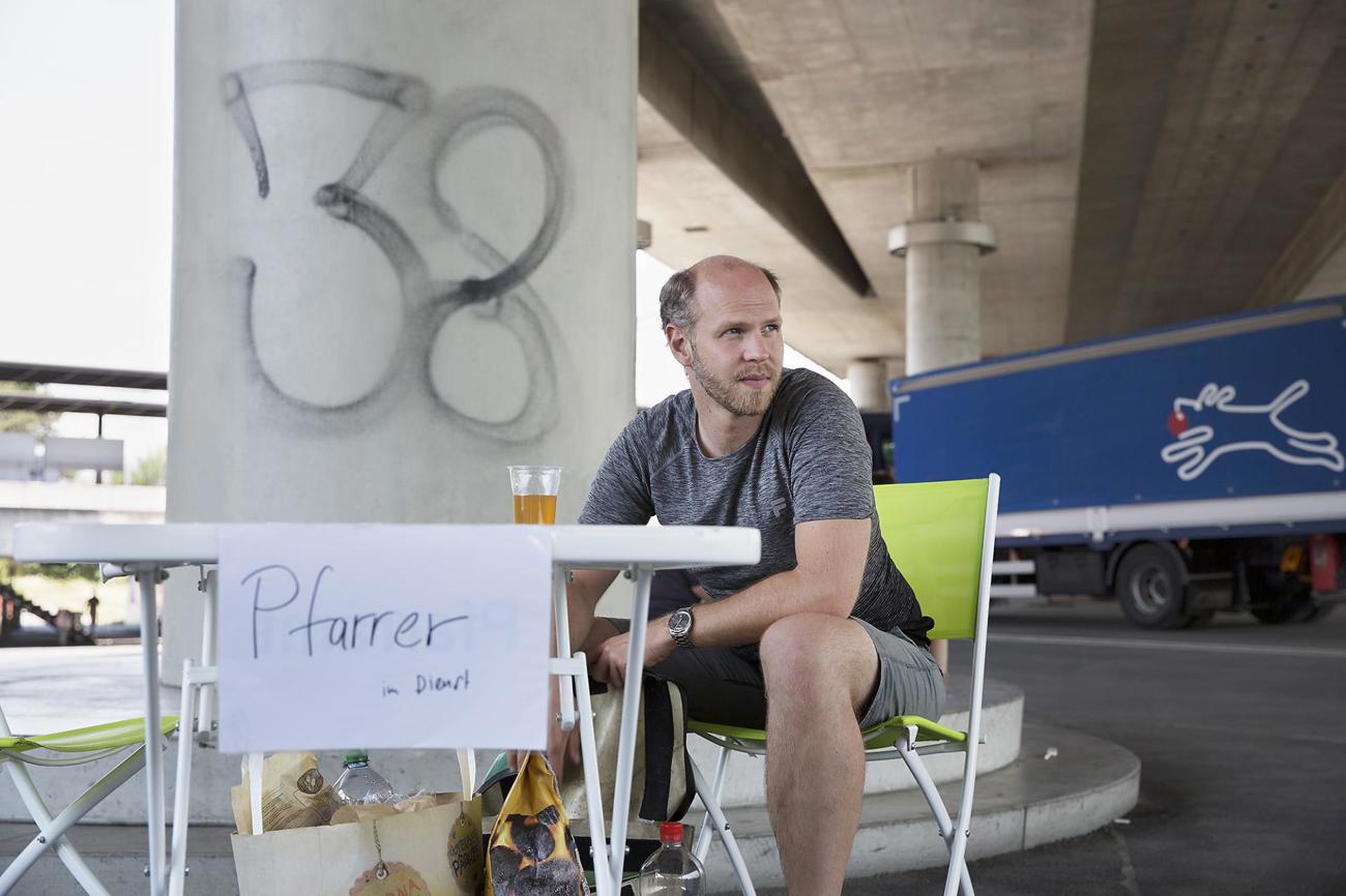 Christian Walti verlegt sein Büro unter den freien Himmel: Pfarramt auf der Gasse auf dem Berner Europaplatz.  / Foto: Nicola Mohler