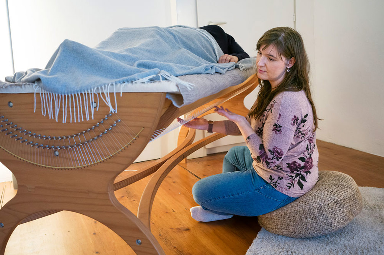Verena Barbera, Musiktherapeutin, betreut eine Patientin auf der Klangliege.  | Foto: Peter Leutert