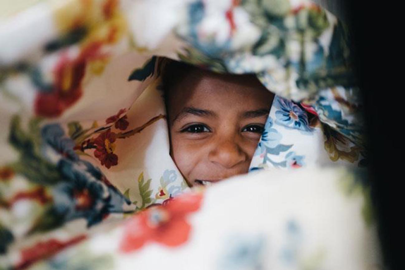 Ein Flüchtlings-Mädchen auf Lesbos freut sich über die Kuscheldecke von «Mini Decki». | Johannes Schulmeister/SAO – Save Assist Outreach