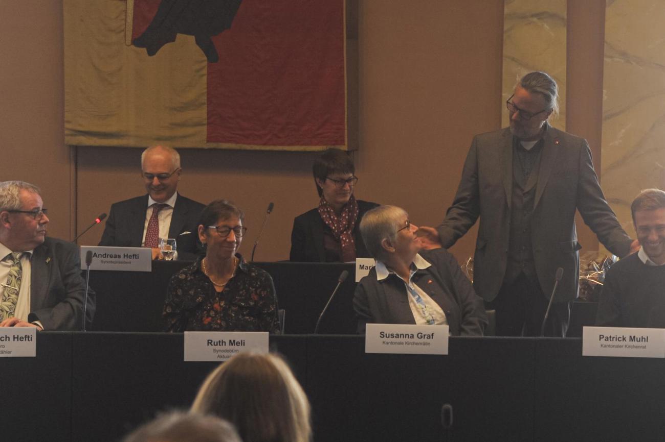 Susanne Graf und Patrick Muhl werden von Kirchenratspräsident Sebastian Doll im Kantonalen Kirchenrat begrüsst.