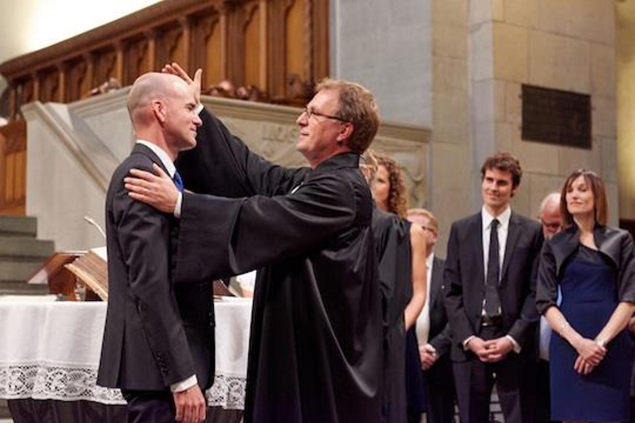Ordinationsfeier im Zürcher Grossmünster: Kirchenratspräsident Michel Müller setzt einen neuen Pfarrer in sein Amt ein (August 2015). | Gion Pfander