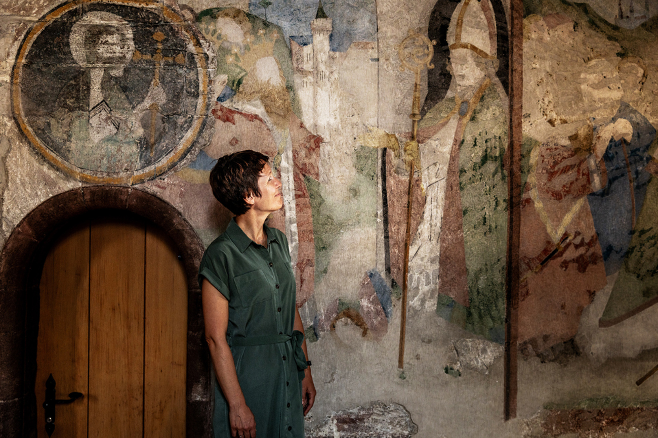 Pfarrerin Sara Stöcklin vor den wiederentdeckten Fresken in der Kirche St. Arbogast in Muttenz. | Foto: Katja Schmidlin