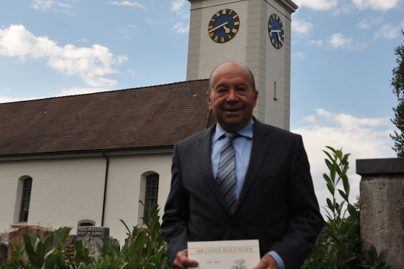 Stolz und vorfreudig: Heinrich Fitzli posiert mit der Festschrift
von 1986 vor der evangelischen Kirche in Matzingen. (Bild: Silas Uhlmann)