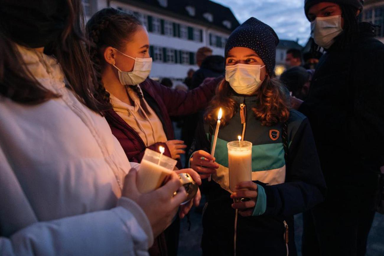 Jugendliche teilen das Friedenslicht auf dem Basler Münsterplatz. |Damaris Thalmann