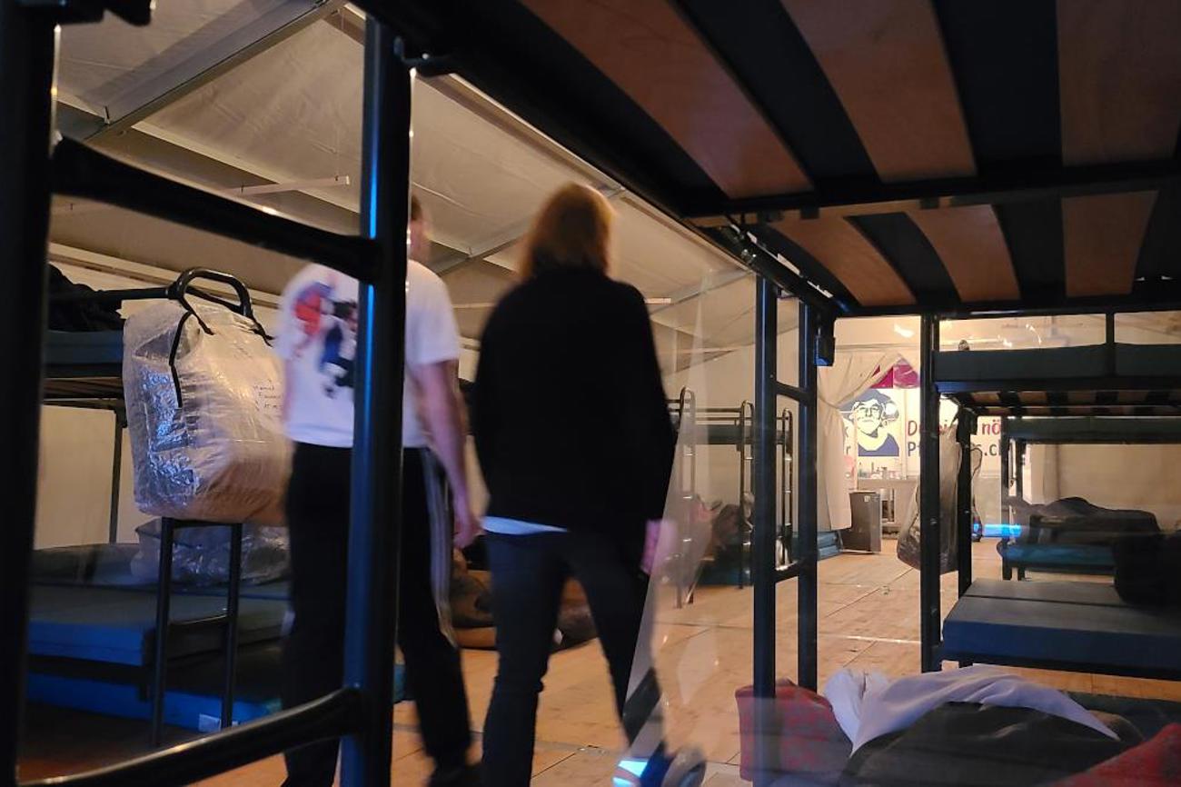 Die Doppelstockbetten, die mit einer Plexiglaswand voneinander getrennt sind, befinden sich in einem Zelt.