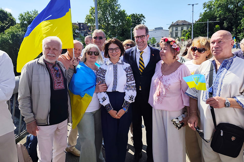 Nach dem Gottesdienst reisten viele Besucherinnen und Besucher nach Basel. Dort bildeten sie eine Menschenkette als Teil einer weltweiten Initiative. In der Mitte: Botschafterin Iryna Venediktova neben Conradin Cramer, dem Regierungspräsidenten von Basel-Stadt.  | Foto: zvg